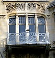 Particolare del balcone ringhierato in ferro battuto, e dell'apparato scultoreo soprastante.