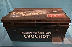 Cantine en métal de couleur noire avec les inscriptions « Maréchal des logis-chef Cruchot », « Congrès international de la gendarmerie » et « New York ».