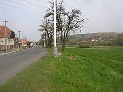 Pohled ulicí Vrapická k východu, v pozadí vpravo domy kolem kostela a Buštěhradská halda