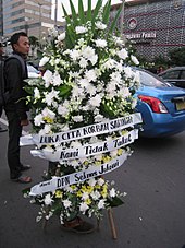 Condolence flowers in front of Sarinah mall. The text says: "Condolences for Sarinah victims, We are Not Afraid, from DPN Seknas Jokowi". 2016 Sarinah-Starbucks Jakarta Attack 5.JPG