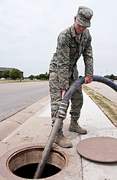 Vacuuming debris from a sewer line CES utilities 120627-F-CC568-041.jpg