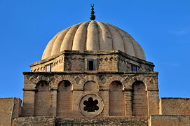 Tambor octogonal de la cúpula elevada del mihrab de la Gran Mezquita de Kairouan (Túnez), de caras ligeramente cóncavas intercalado entre la cúpula acanalada y la base ornamentada con nichos de fondo plano.