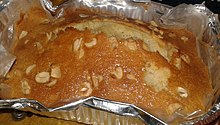 A butter cake made with cashew nuts on an air fryer, in an aluminium foil container.
