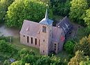 Kirche mit angebautem Gemeindehaus und umgebender Grünfläche