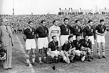En noir et blanc, une équipe de football pose. De trois-quarts, sept joueurs sont debout et quatre accroupis.