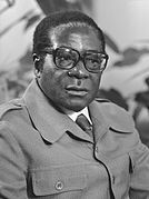 Роберт Мугабе в темном костюме и очках смотрит направо от зрителя.