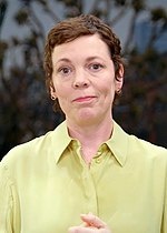 Colman, looking pensive with short hair and wearing a light-colored blouse