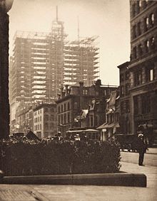 The photograph "Old and New New York" by Alfred Stieglitz. The photo was most likely taken on the North side of 34th, just east of 5th Avenue, facing east, with the building under construction being the Vanderbilt Hotel which stands along the east side of Park, between 33rd and 34th. The tower in the background is the 71st Regiment Armory (now demolished), which sat on the southwest side of Park and 34th.