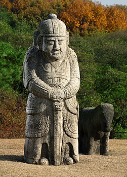 Estátua de um oficial militar e um cavalo ao redor do túmulo de Seongjong de Joseon em Seolleung, Coreia do Sul. Seongjong (1457-1495) foi o nono rei da Dinastia Joseon da Coreia. Seu reinado foi marcado pela prosperidade e crescimento da economia nacional, com base nas leis estabelecidas pelos reis Sejong e Sejo. Ele próprio foi um governante talentoso. Em 1474, o código de lei, ordenado pela primeira vez pelo rei Sejo, foi concluído e colocado em vigor. Ele trouxe muitos confucionistas liberais para sua corte, cujas opiniões políticas iam contra as dos funcionários conservadores. Desta forma, tornou seu governo mais eficaz, nomeando administradores competentes, independentemente de suas opiniões políticas. Sua política resultou em muitas inovações positivas, aumentando seu número de apoiadores. O próprio rei era um artista e estudioso e gostava de discutir os pontos mais delicados da política com estudiosos mais liberais. Ele encorajou acadêmicos a publicar vários livros sobre geografia e etiqueta social, por exemplo, bem como áreas do conhecimento que beneficiavam as pessoas comuns. (definição 2 563 × 3 559)