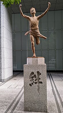 Statut représentant un coureur franchissant la ligne d'arrivée de l'Ekiden devant le siège du Yomiuri Shinbun.