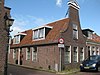 Huis voorzien van een klokgevel met fronton