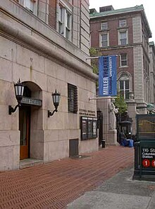 The Miller Theatre entrance is pictured. Two lanterns hang either side of two wooden doors.