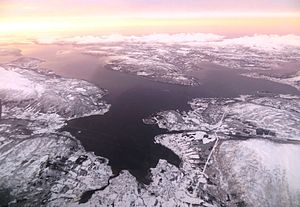 Reisafjord (vorn), Solbergfjord (links), Finnfjord (rechts), die Insel Senja (oben im Hintergrund)