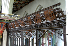 Parclose screen, c. 1530, of the Moorhayes Chapel, Cullompton Church, Devon, England. Looking north-west from within the chancel. Part of the brightly decorated, higher, chancel screen is visible beyond. Screen MoorhayesChapel CullomptonChurch Devon.PNG