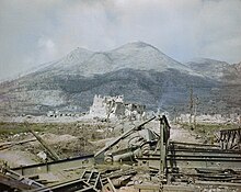 The ruins of Cassino town with a knocked-out Sherman tank by a Bailey bridge in the foreground with Monastery Ridge and Castle Hill in the background, May 1944. (This photograph has been reversed and so depicts a mirror image of the actual scene.) The ruins of Cassino, May 1944- a wrecked Sherman tank and Bailey bridge in the foreground, with Monastery Ridge and Castle Hill in the background. TR1799.jpg