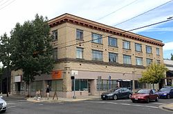 Photograph of the Alco Apartments, a three-story building on a city street corner
