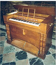 Photographie d'un instrument de musique en bois posé sur du carrelage.