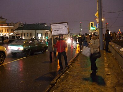 A protestor walks onto a road holding a placard in his right hand Imagem: Lvova Anastasiya.