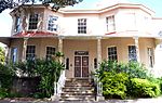 A double storey building in a plaster finish, with a cast iron veranda and small pane sash windows. The building is finely detailed and the internal spiral staircase is of special note. It is one of the first villas to have been built in this area. The b William Fleming was born in London in 1796 and arrived in Table Bay on 24 April 1818. He moved to Port Elizabeth in 1842 and joined the firm of Peter Heugh in which he became a partner, the firm being known as "Heugh and Fleming". Fleming was deeply invol Architectural style: A Regency double storey villa.. Type of site: House Previous use: Residential. Current use: Educational. Fleming House is an excellent example of a dwelling of a wealthy merchant in the mid-19th Century, executed in the Regency style. Built in 1853, the house has close associations with a number of leading citizens in the Cape Colony. During the 20th Century