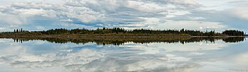 Reflexos no Refúgio Nacional de Vida Selvagem de Tetlin, Alasca, Estados Unidos. O Refúgio de Tetlin é uma paisagem dinâmica composta de florestas, zonas úmidas, tundra, lagos, montanhas e rios glaciais delimitados pelos picos nevados da cordilheira do Alasca. Este vale superior do rio Tanana foi chamado de “Passagem de Tetlin”, porque serve como uma importante rota migratória para as aves que viajam de e para o Canadá, de 48 rios e das Américas Central e do Sul. Muitas dessas aves se reproduzem e nidificam no refúgio. O Refúgio de Tetlin também abriga uma variedade de grandes mamíferos. Duas das seis áreas conhecidas de desova de peixe-branco-corcunda na drenagem do rio Yukon estão localizadas no refúgio. Com o caribu e o alce, esses peixes são importantes recursos de subsistência para os residentes da área. (definição 13 226 × 3 869)