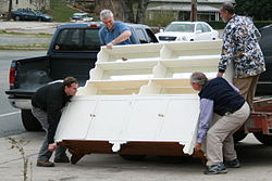 Four men lifting a heavy sideboard.