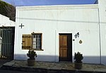 Single storey with flat roof and cornice. Asymmetrical two bay facade adjoining No 28, with edge pilaster on left and door frame surround. Low stoep. 12-light casement window with solid shutter. Horizontally divided door with one large panel in each leaf Land first surveyed, and transferred in 1862. Type of site: House Current use: Residential : House. This house is representative of early Karoo architecture. The building is square with fine cornice.