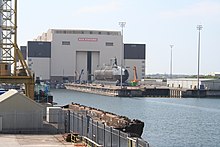 Submarine HMS Astute on a shiplift, being brought out of the building hall towards the water Astute2.JPG