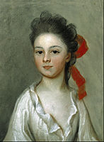 Retrato de medio cuerpo de niña joven con lazo en el pelo y camisa blanca