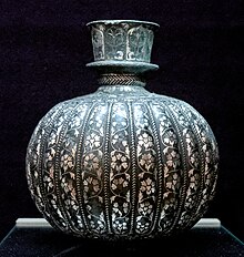 A decorated metal vase on display