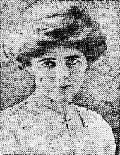 A grainy newspaper photo of a woman in her early 20s who looks straight at the camera. Her hair is coiffed, and she is wearing a white blouse