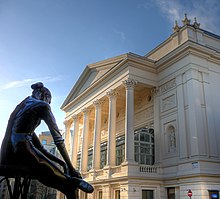 exteriér neoklasického divadla se sochou mimo balerínu