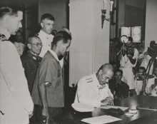 British Rear Admiral Sir Cecil Halliday Jepson Harcourt watching Japanese Vice Admiral Ruitako Fujita sign the document of surrender on 16 September 1945 in Hong Kong. Signing of the Japanese Surrender of Hong Kong.png