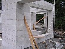 Photographie montrant le bâti en construction d'une maison en blocs en béton cellulaire disposés de la même manière que pour les maisons en brique.