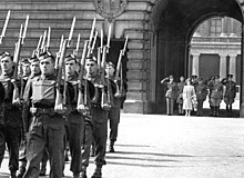 George VI, king of Canada, salutes, with his consort, Queen Elizabeth beside him, as the Toronto Scottish Regiment mount the King's Guard at Buckingham Palace, December 1939 Torontoscottishkingsguard.jpg
