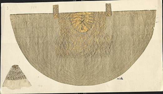 Ett halvcirkelrunt tyg i vitt och guld, med kristusmonogram.