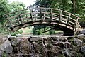 Die Holzbrücke in asiatischem Stil am Auslauf des Fischteiches