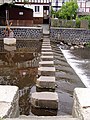 Die Schrittsteine über die Lauter (mit Strolchdenkmal im Hintergrund) in: Lauterbach (Hessen)