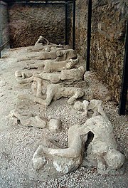 The 79 eruption of Mount Vesuvius completely destroyed Pompeii and Herculaneum. Today plaster casts of actual victims found during excavations are on display in some of the ruins.