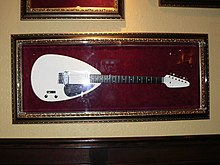 A white teardrop shaped guitar as used by Brian Jones, on display at the Hard Rock Cafe in Sacramento, California