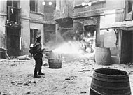 A German soldier sets fire to a building