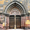 A side portal. The tympanum is signed by a "Master Humbret".