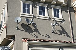 DBS satellite dishes installed on an apartment complex. Dishing out the truth.JPG