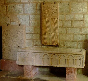 Le sarcophage du XIe siècle sous les plaques tumulaires mérovingienne et carolingienne.