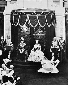 King George VI, accompanied by Queen Elizabeth, grants royal assent to laws in the Canadian Senate, 19 May 1939 RoyalVisitSenate.jpg