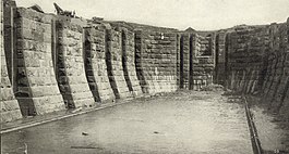A ship railway dock, consisting of a deep reservoir surrounded by walls of large stone bricks with vertical channels for machinery.