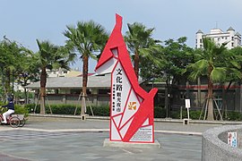 立于文化路南端与垂杨路交界的文化路观光夜市标志，后方为嘉义市文化公园。