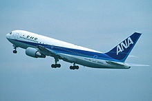 An All Nippon Airways in blue and white livery during takeoff, with landing gears still down.