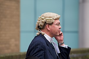 English: A barrister on a mobile phone outside...