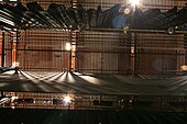 Channel-type grid, viewed from below with drapes, battens, and electrics visible.