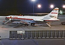 photo de nuit, caravelle stationnée. La rampe arrière est abaissée, et une passerelle positionnée sur la porte gauche.